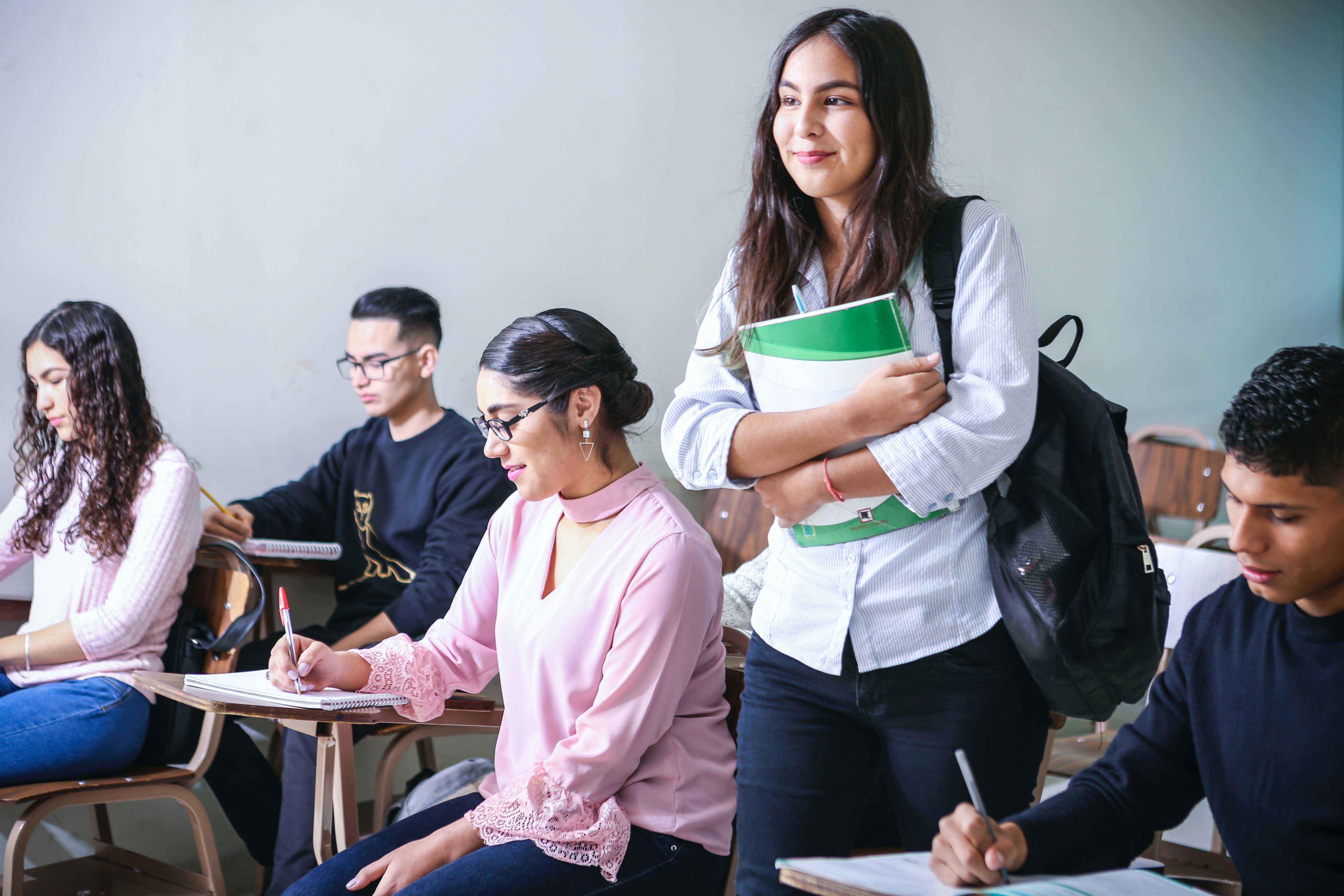 Student standing in a classroom surrounded by students in seats